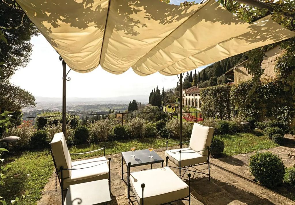 Terrasse mit schattenspendendem Segel, Sitzgruppe und Blick auf die toskanische Landschaft