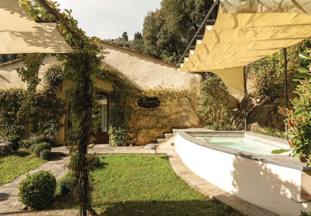 Grüne Gartenanlage mit kleinem Pool und traditioneller Architektur
