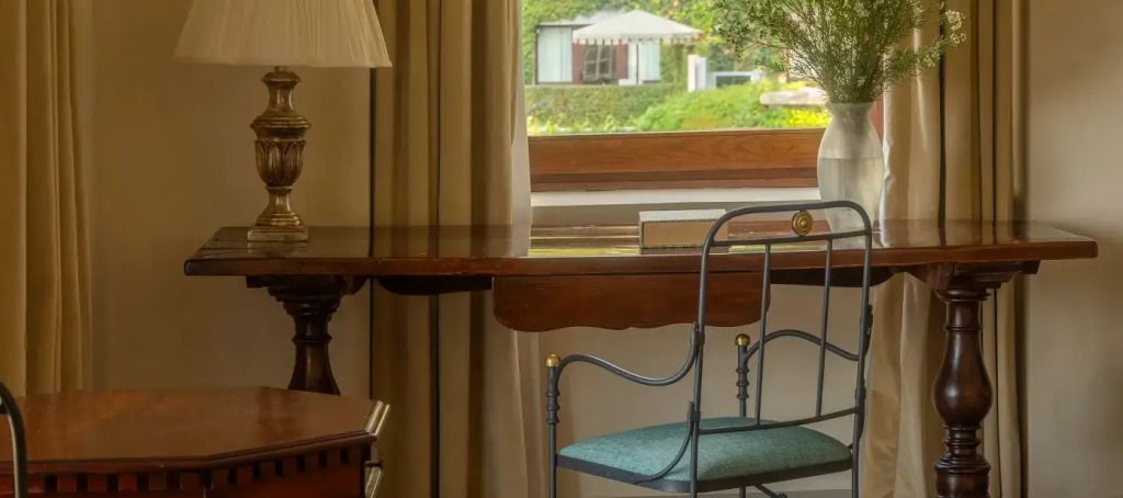 Elegantes Arbeitszimmer mit Blick in den Garten und antiken Möbeln