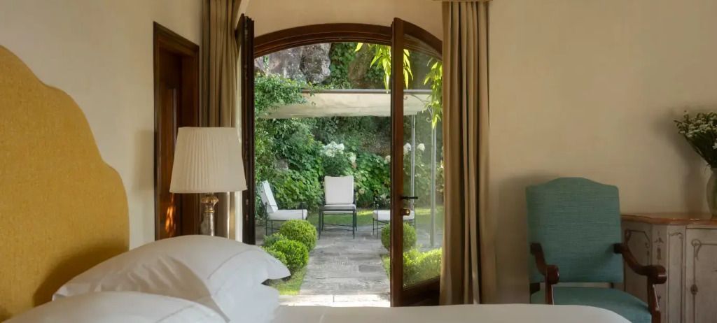 Schlafzimmer mit Balkon und Aussicht auf eine grüne Garten-Oase