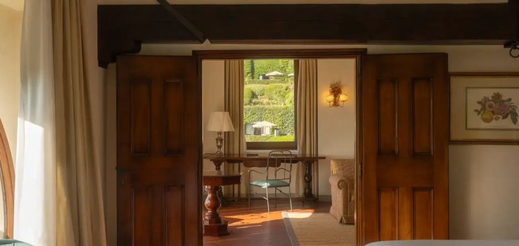 Blick durch die Holztür auf den elegant eingerichteten Raum mit Gartenblick