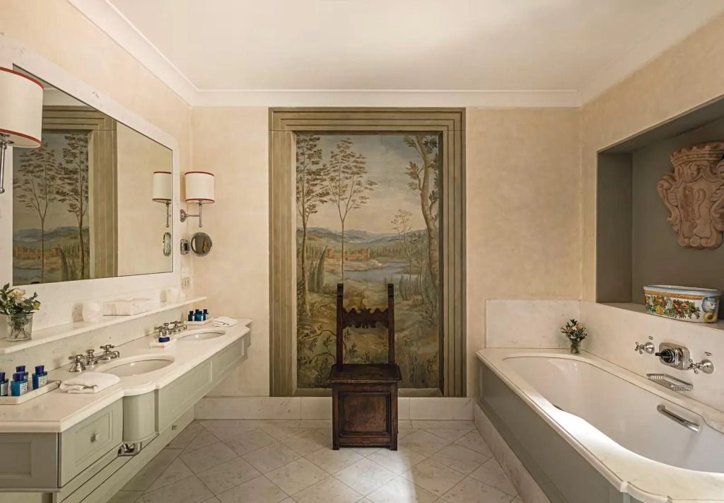 Badezimmer in der Suite mit Wandmalerei und klassischer Badewanne.