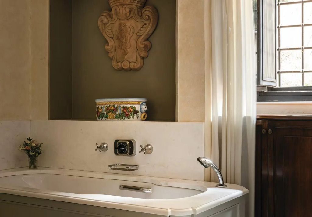 Detail der Badewanne mit dekorativer Keramik in Nische und natürlichem Licht.