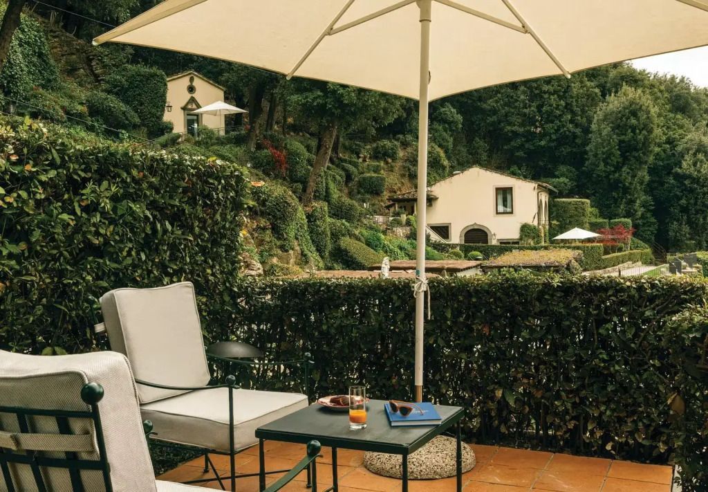Sonnendurchflutete Terrasse mit Sitzbereich und Ausblick auf die hügelige Landschaft
