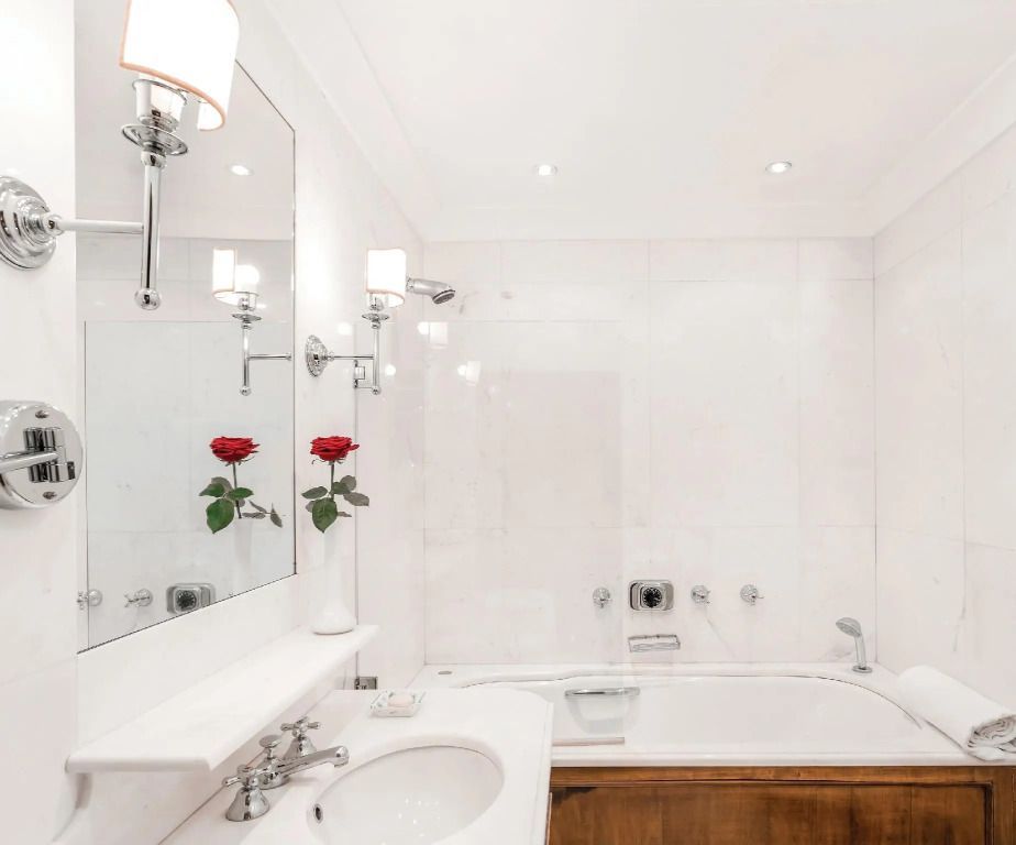 Weitläufiges Badezimmer mit stilvollen Elementen und Rosen in der Vase