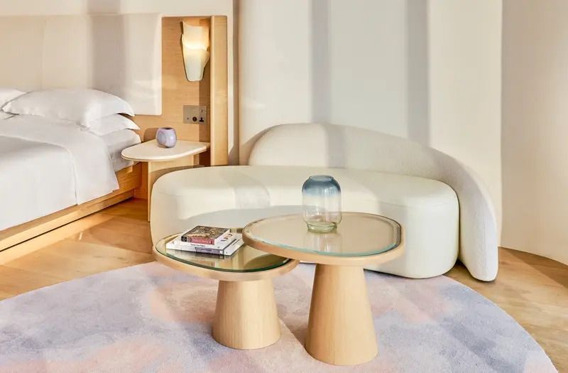 Couch und runder Tisch mit Glasplatte in einem modernen Hotelzimmer