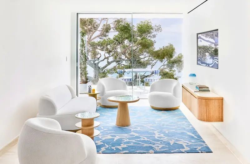 Modernes Wohnzimmer mit Glasfront und Blick ins Grüne.