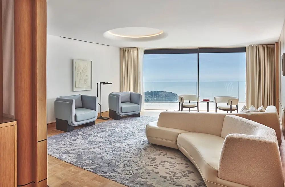Moderner Wohnbereich in einer Suite mit Panoramafenstern und Meerblick