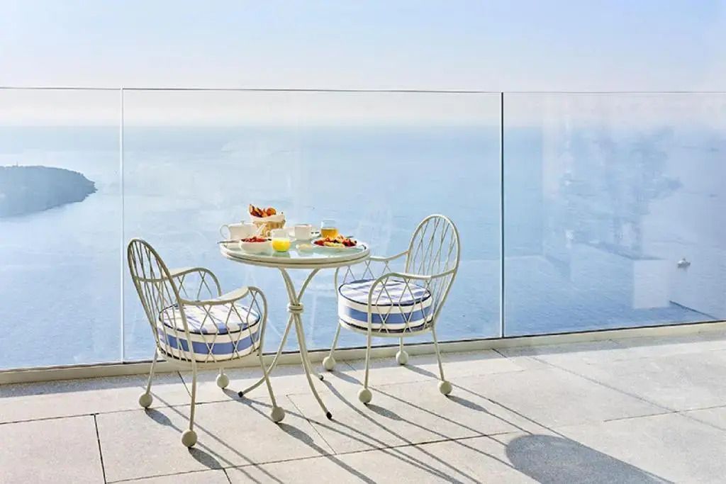 Terrasse mit stilvollen Sitzmöbeln und herrlichem Blick auf das Meer