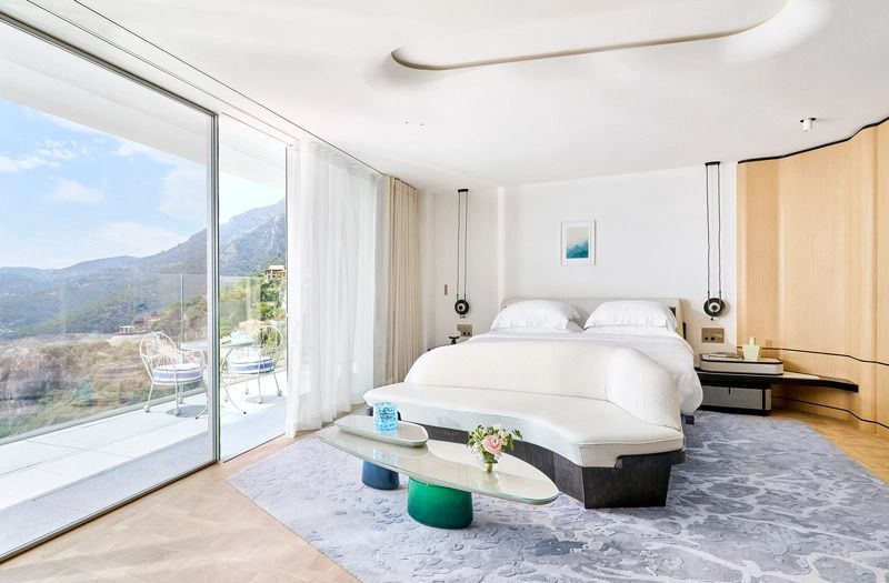Elegantes Schlafzimmer mit Doppelbett und großem Fenster mit Meerblick