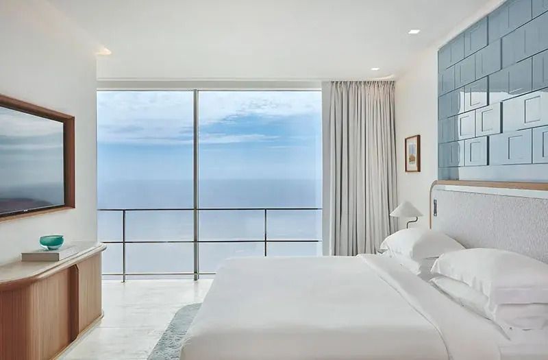 Geräumiges Schlafzimmer mit Panoramablick auf das Meer durch große Fenster