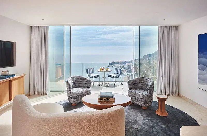 Gemütlicher Lounge-Bereich mit Sitzecke und spektakulärem Blick auf Küste und Meer