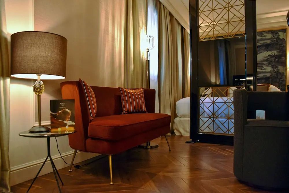 Elegante Lounge-Ecke mit rotem Sofa und modernem Dekor im Deluxe Doppelzimmer