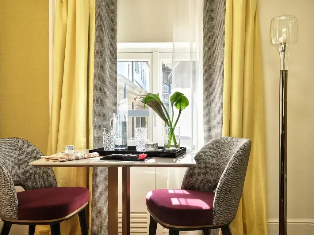 Heller Sitzbereich mit Tisch und zwei Stühlen vor einem Fenster
