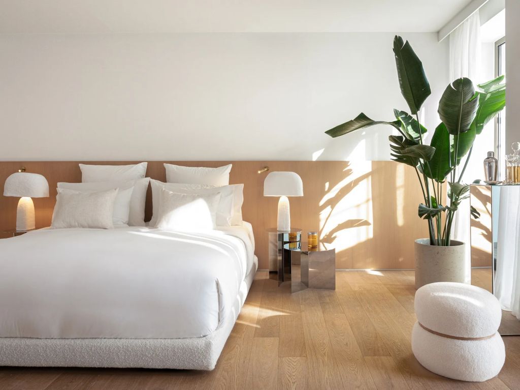 Helles Doppelzimmer mit großen Pflanzen und minimalistischem Dekor