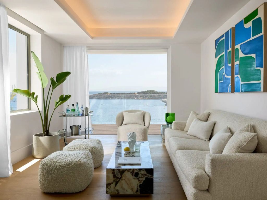 Helles Wohnzimmer mit modernen Möbeln und Panoramablick auf die Marina.