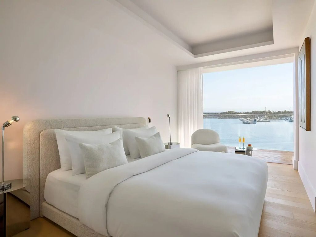 Geräumiges Schlafzimmer mit großem Bett und Blick auf die Marina.