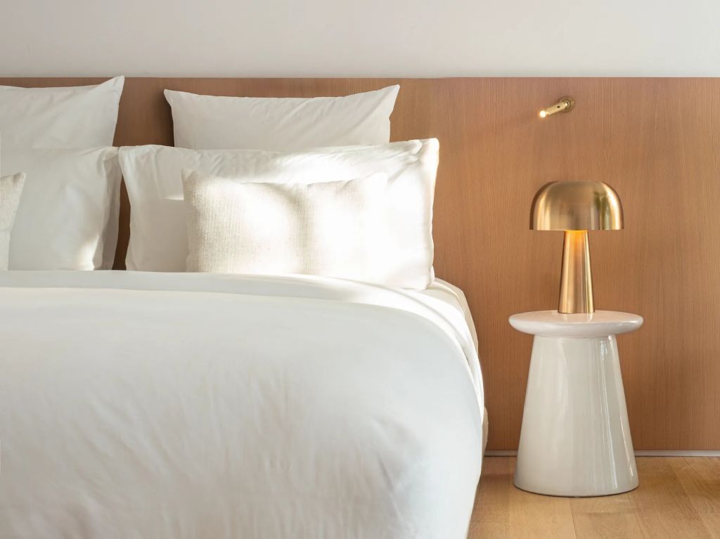 Modernes Doppelzimmer mit gemütlichem Bett und Designer-Lampe am Nachttisch