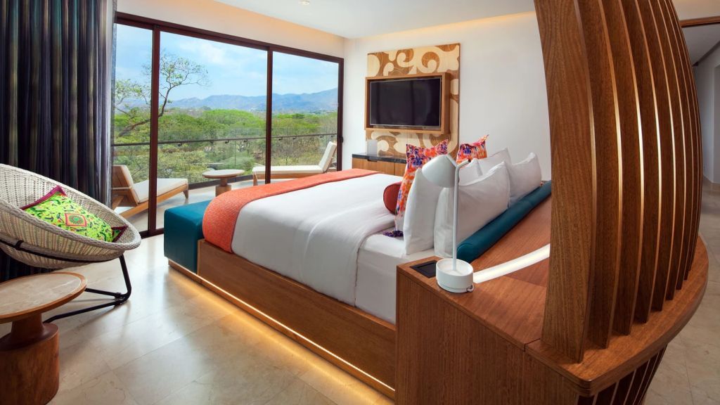 Geräumiges Schlafzimmer mit Doppelbett und Blick auf die Natur.