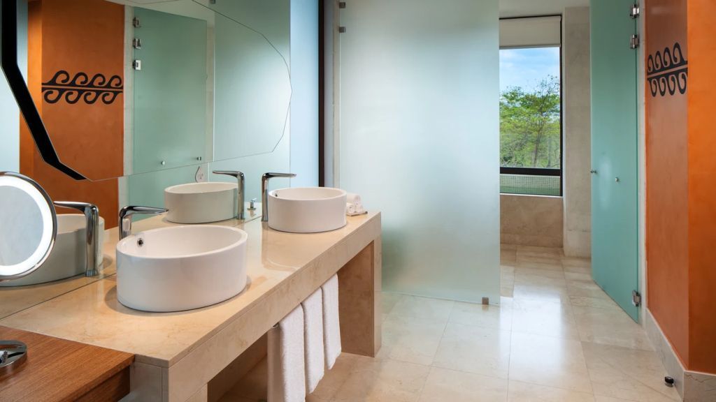 Luxuriöses Badezimmer mit zwei runden Waschbecken und großem Spiegel.