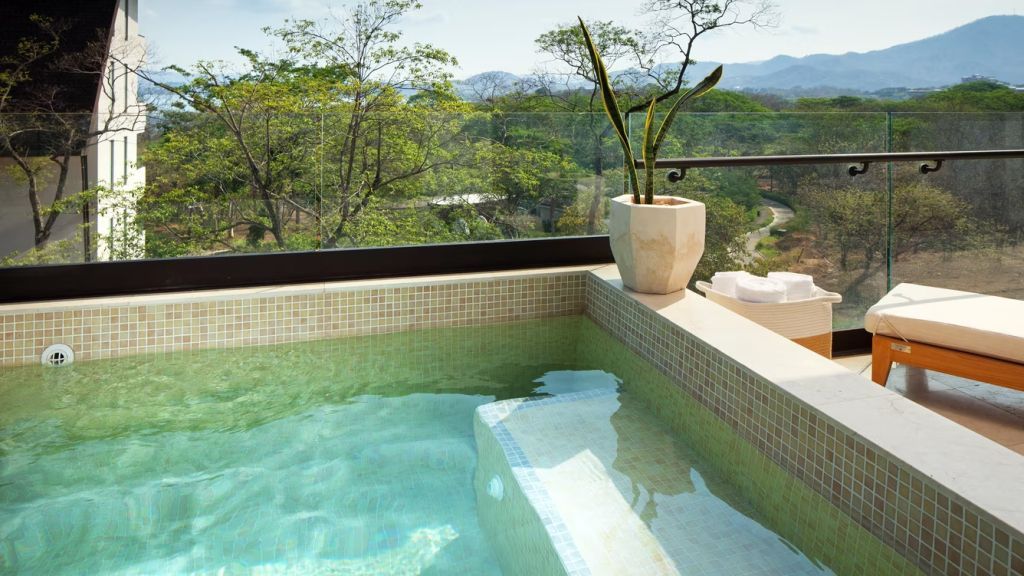 Privater Whirlpool auf der Terrasse mit Ausblick auf die Berge.
