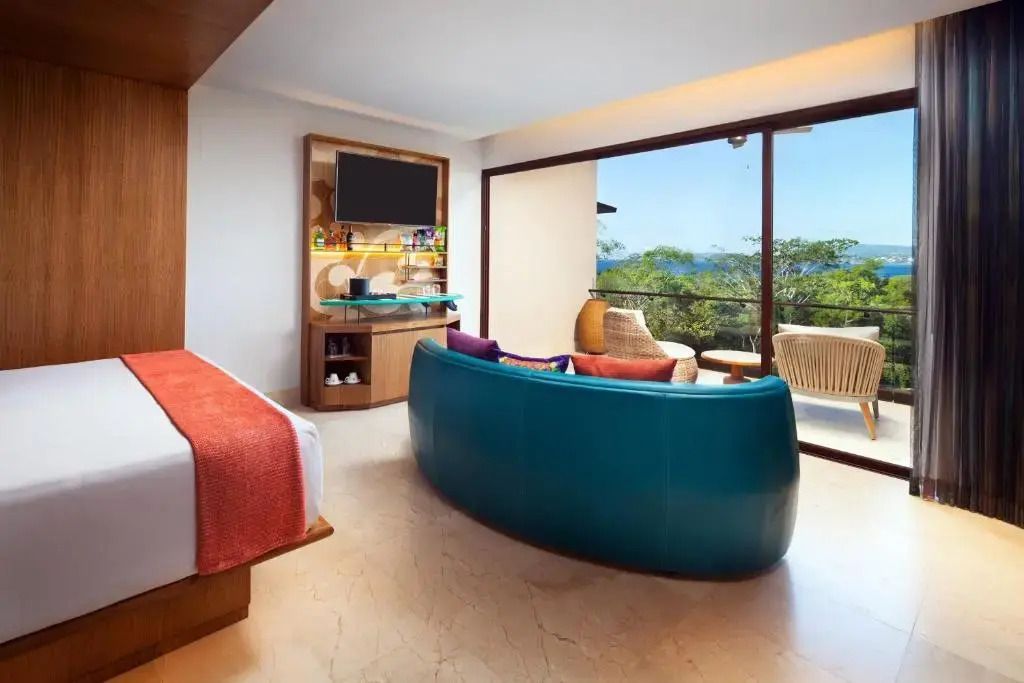 Modernes Hotelzimmer mit Doppelbett, großem Fenster und Balkon mit Aussicht