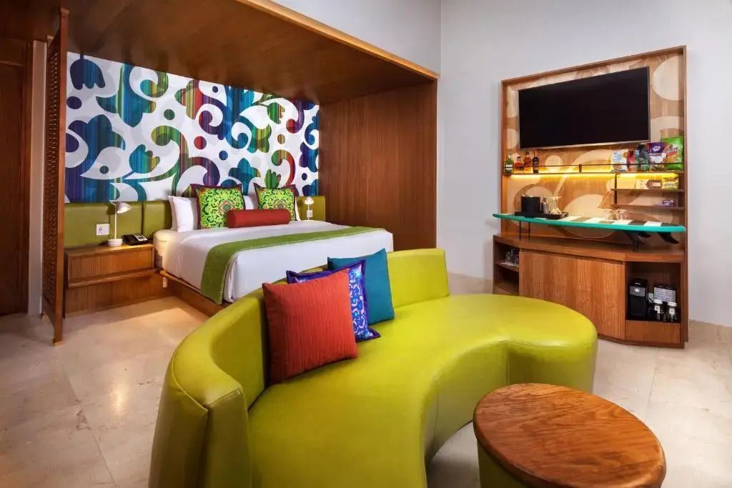 Modernes Doppelzimmer mit bunten Kissen und künstlerischem Kopfteil