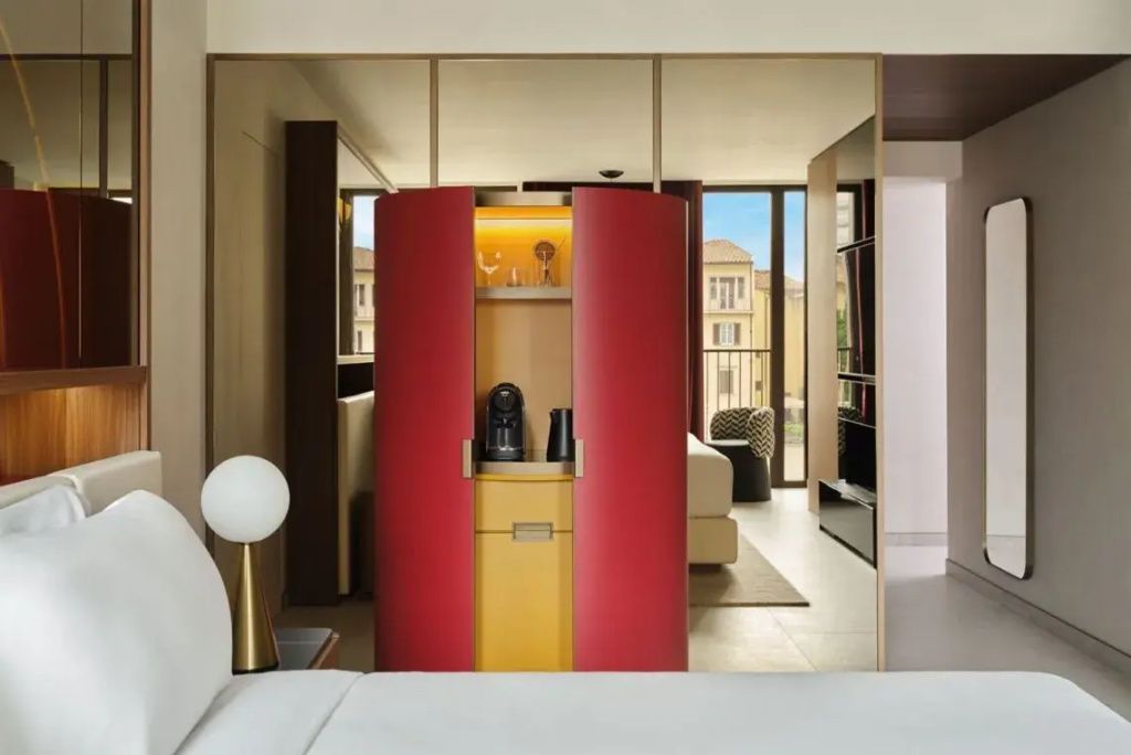 Moderne Suite mit auffälligem roten Möbelstück und Blick auf die Stadt.