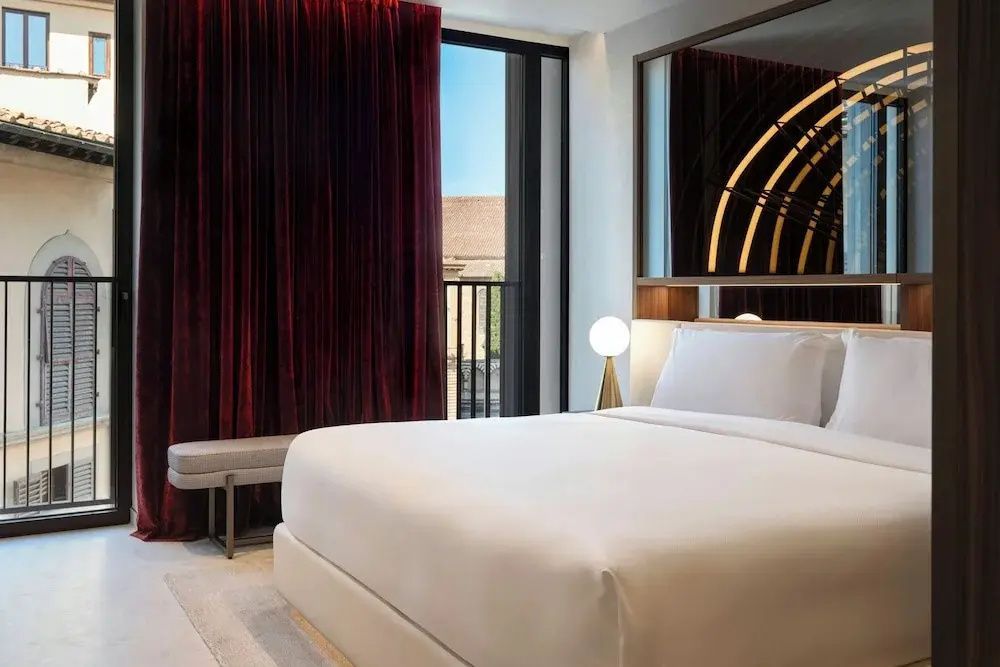 Modernes Hotelzimmer mit großem Bett und Blick aus Fenster