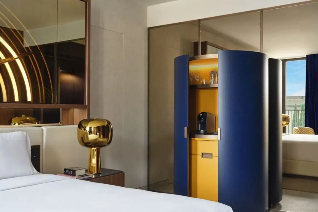 Stilvolle Ecke mit modernem blauen Schrank, goldener Lampe und luxuriöser Wandverkleidung.