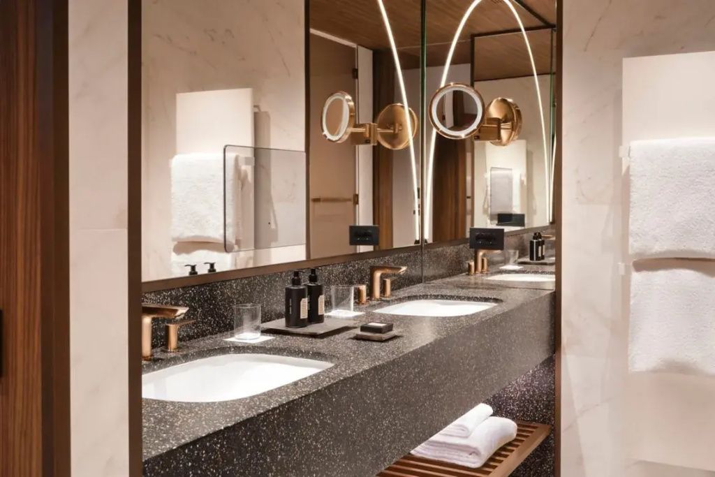 Luxuriöses Badezimmer mit Doppelwaschbecken aus Marmor und edlen Armaturen.
