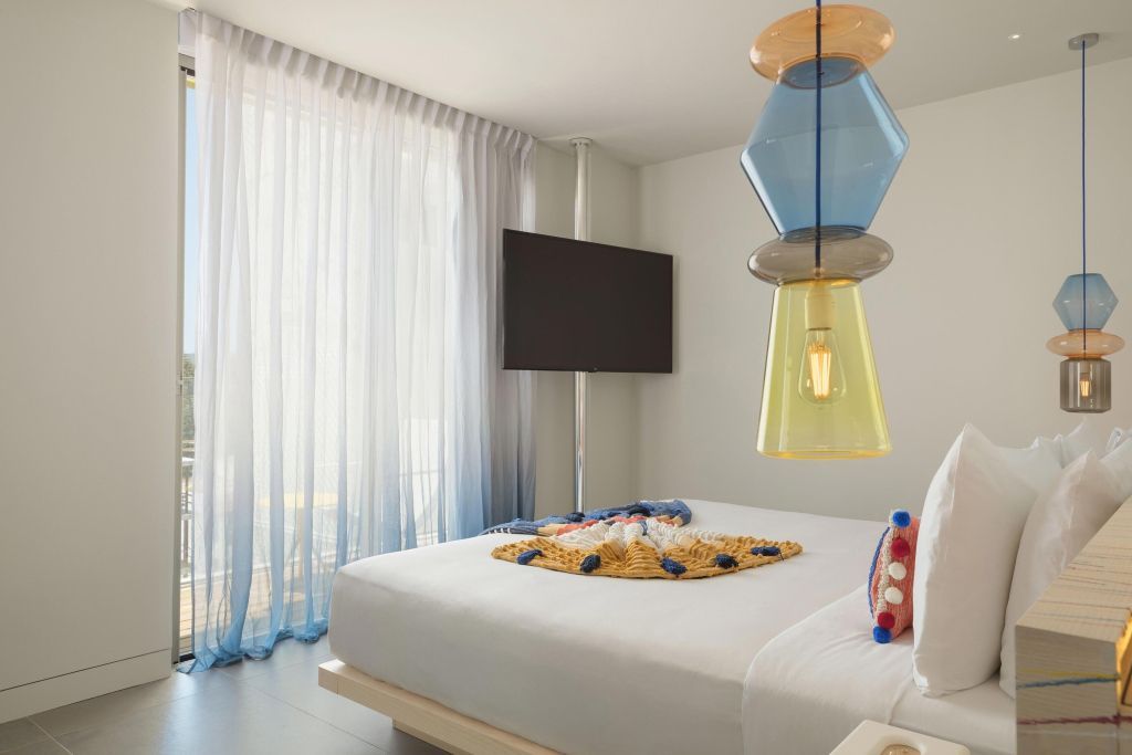 Modernes Schlafzimmer mit elegantem Beleuchtungselement und großem Fernseher in der Ewow Doppel Suite
