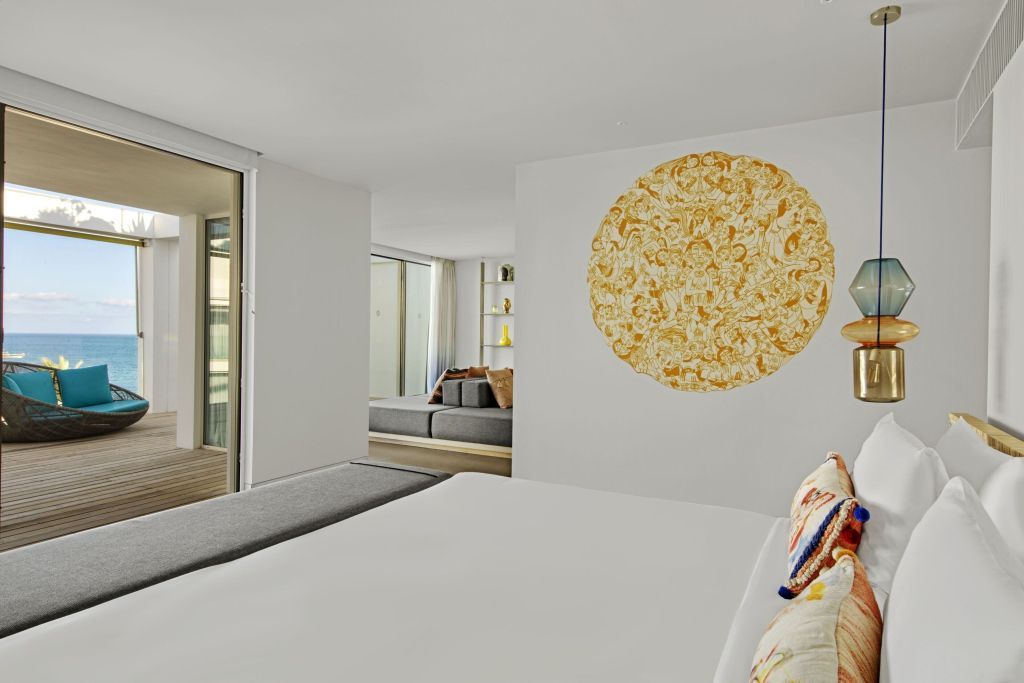 Zimmer mit Doppelbett und dekorativer Wandkunst in der Ewow Doppel Suite
