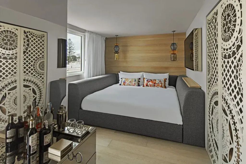 Großes Doppelbett in einem eleganten Hotelzimmer mit Holzverkleidung