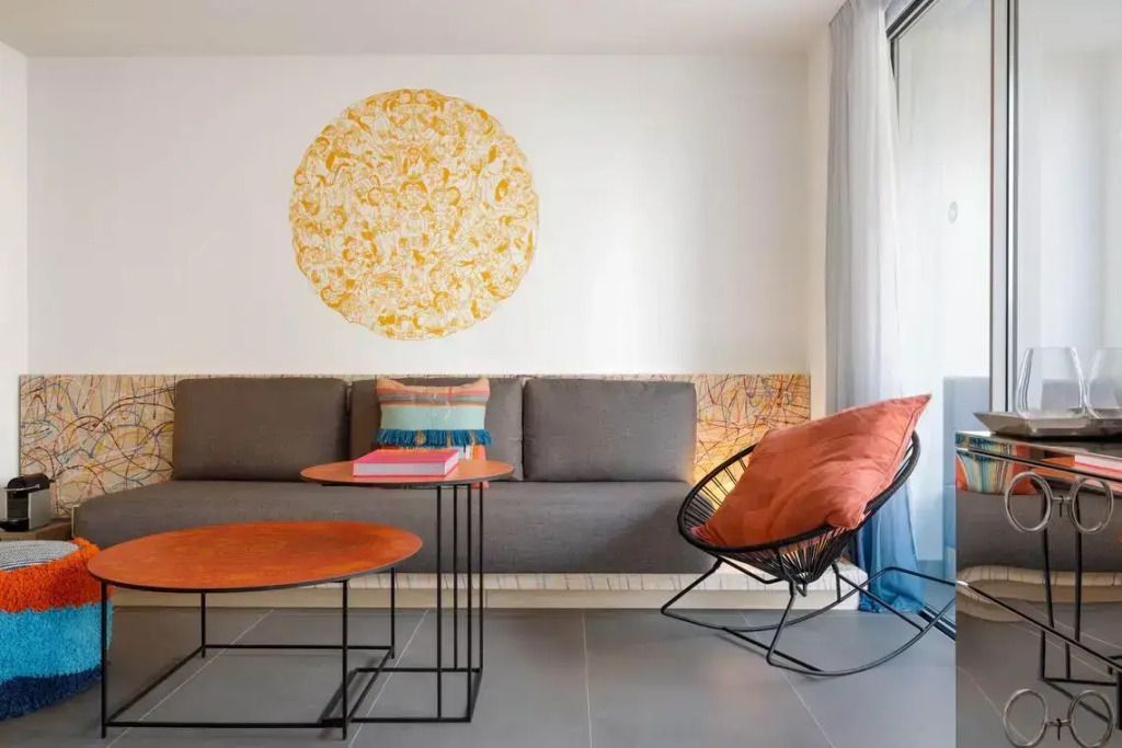 Heller Sitzbereich mit Designer-Möbeln und künstlerischer Wanddekoration