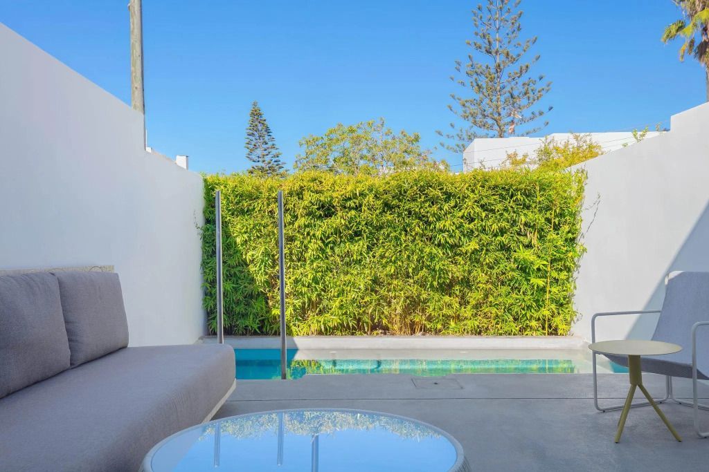 Private Terrasse mit kleinem Pool und grüner Hecke