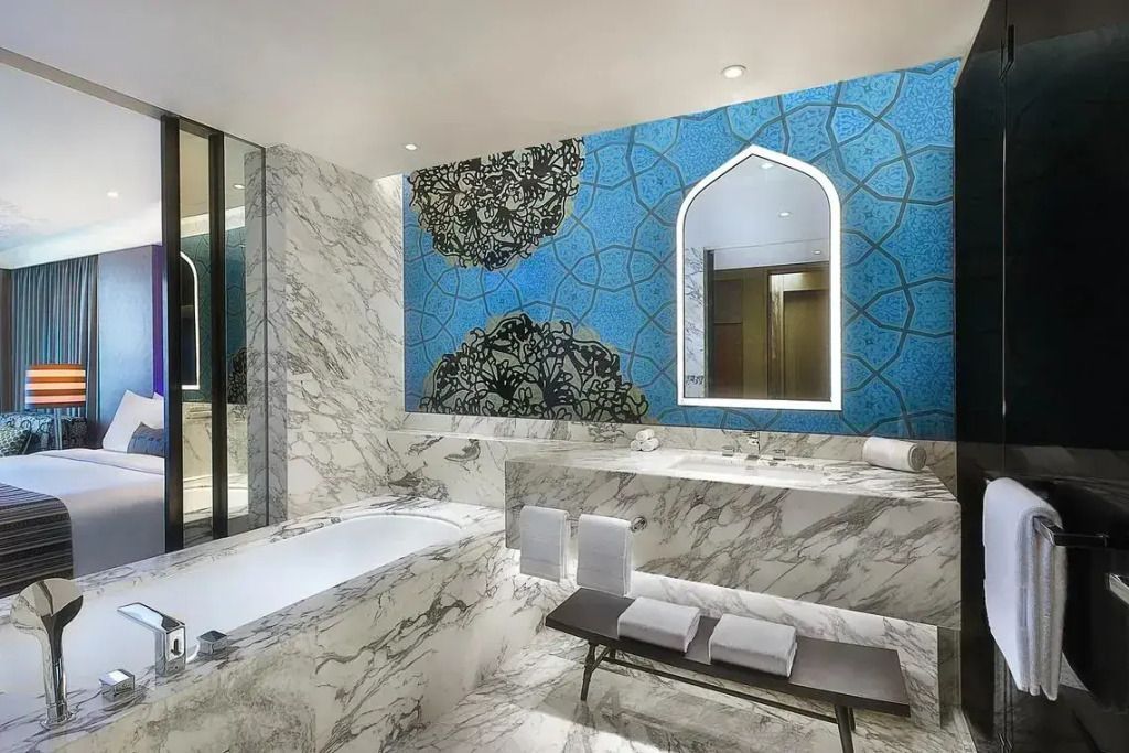 Luxuriöses Badezimmer mit Marmorverkleidung und elegantem Spiegel.