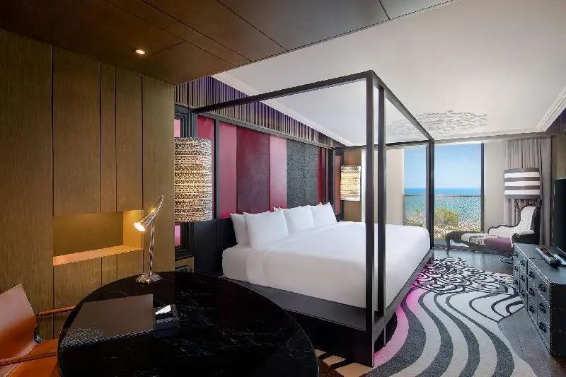 Luxuriöses Schlafzimmer mit atemberaubendem Blick auf das Meer, Himmelbett und modernem Design.