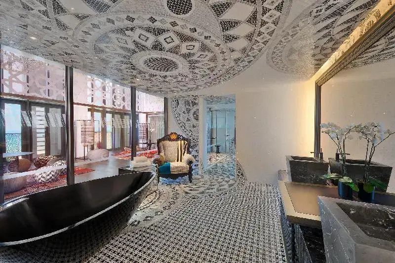 Elegantes Badezimmer mit auffälligem Mosaikdesign und freistehender Badewanne.