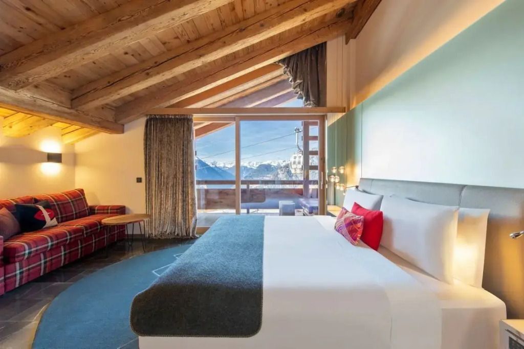 Geräumige Junior-Suite mit Doppelbett und Panoramablick auf die Alpen.