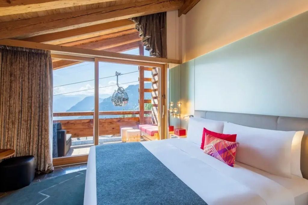 Luxuriöse Suite mit modernen Akzenten und Balkon mit Bergblick.