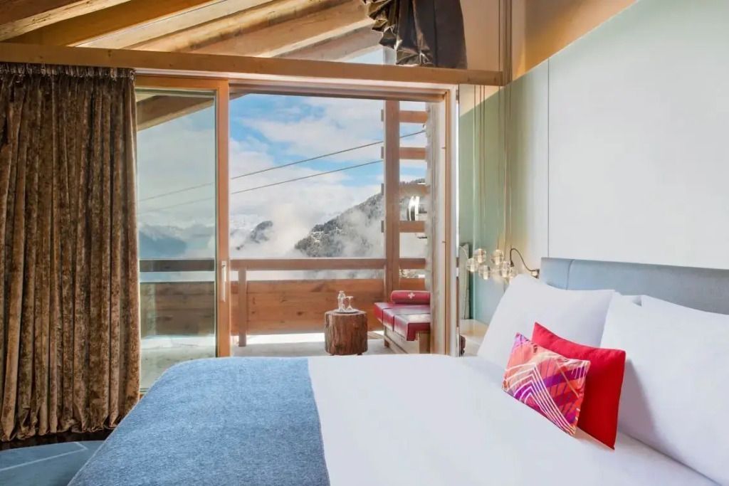 Suite mit Balkon und grandiosem Ausblick auf die Wolken und Berge.