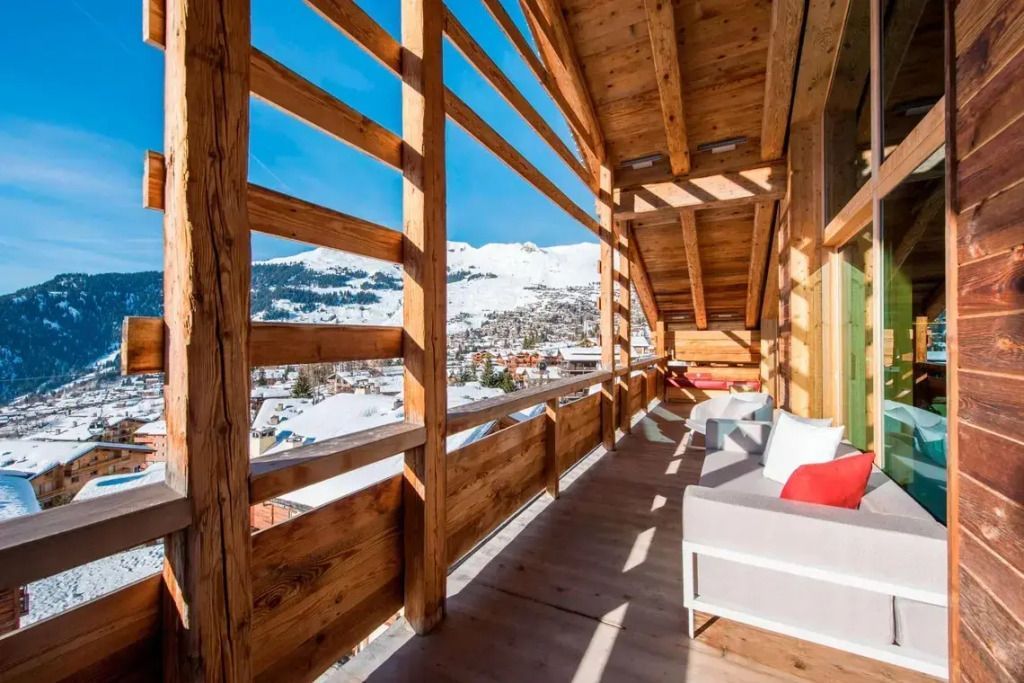 Geräumiger Balkon aus Holz mit Bergblick im Winter.