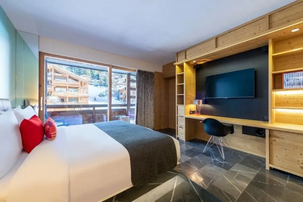 Modernes Hotelzimmer mit Blick auf die schweizerischen Alpen und Holzinterieur