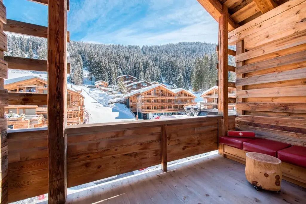 Balkon mit Panoramablick auf die verschneiten Bergchalets