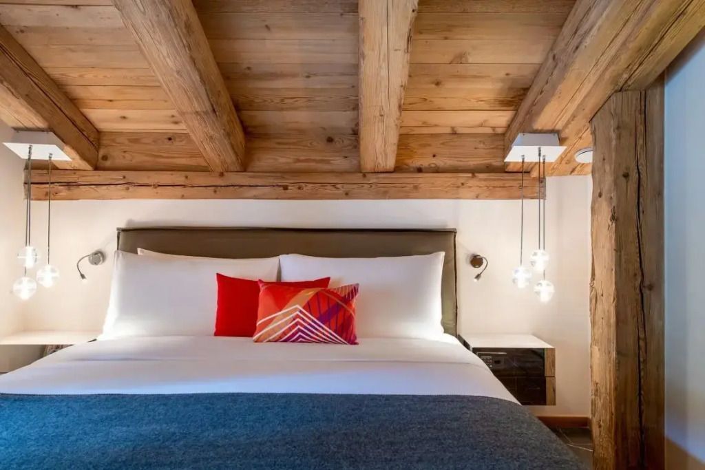 Helles Schlafzimmer mit rustikalem Holzdesign und farbigen Kissen.