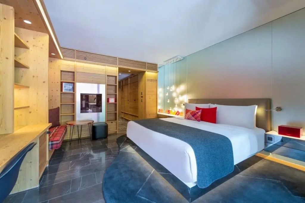 Großes Hotelzimmer mit Doppelbett, Holzelementen und modernem Design