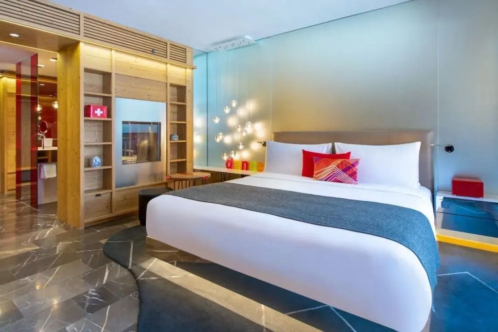 Luxuriöses Hotelzimmer mit großen Bett, hellem Holz und stilvoller Beleuchtung
