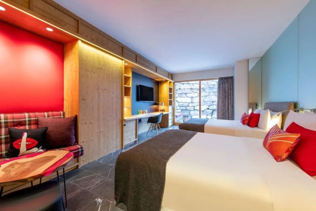 Helles Hotelzimmer mit zwei Einzelbetten in modernem, alpinem Stil und großem Fenster.