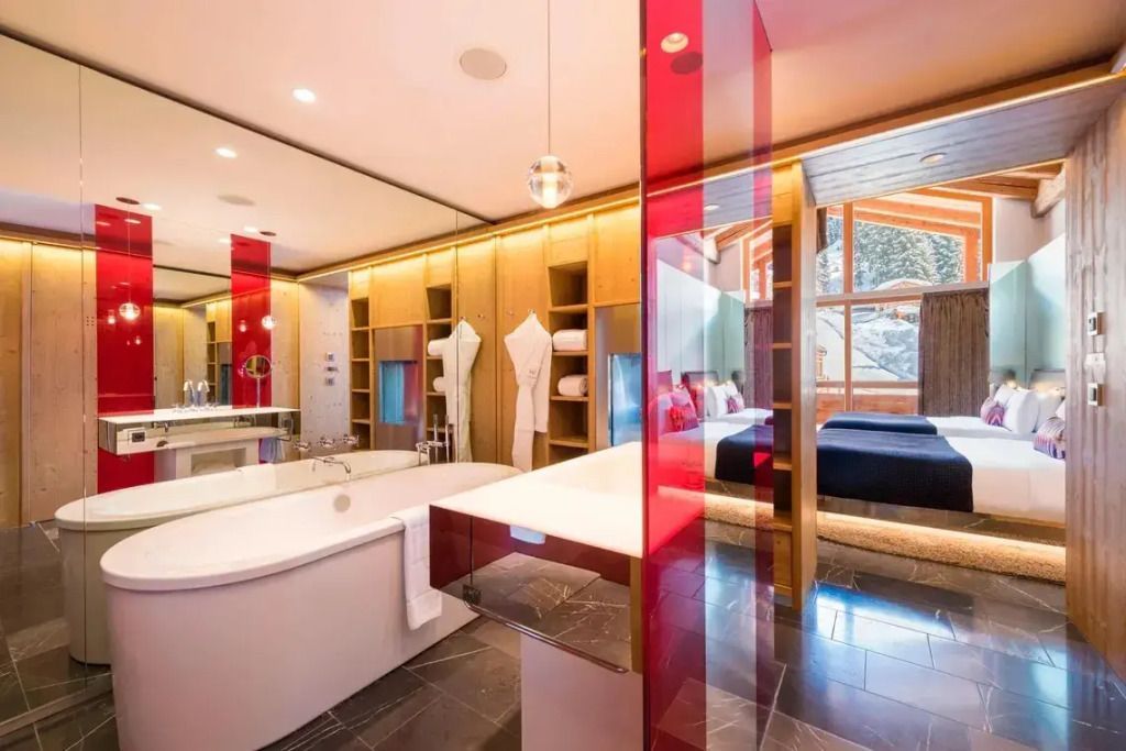 Luxuriöses Badezimmer mit freistehender Badewanne und Blick in das Zimmer.